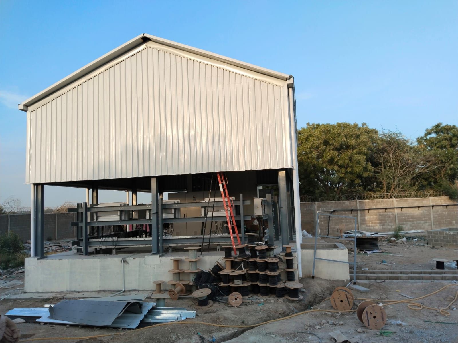 Completed inverter station with DC cable drums staged on site