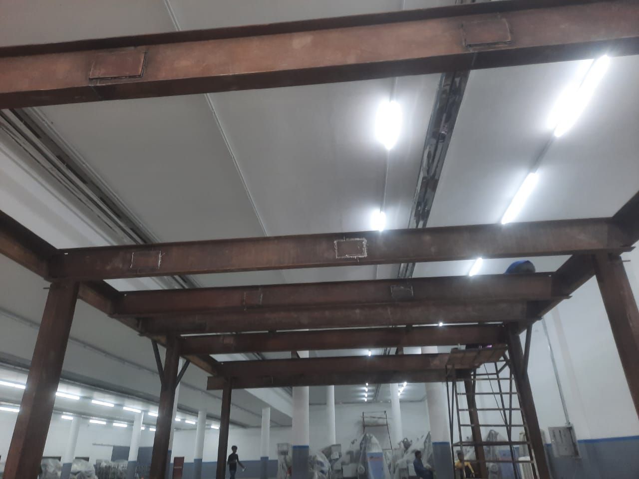Structural steel mezzanine frame erected inside a production hall